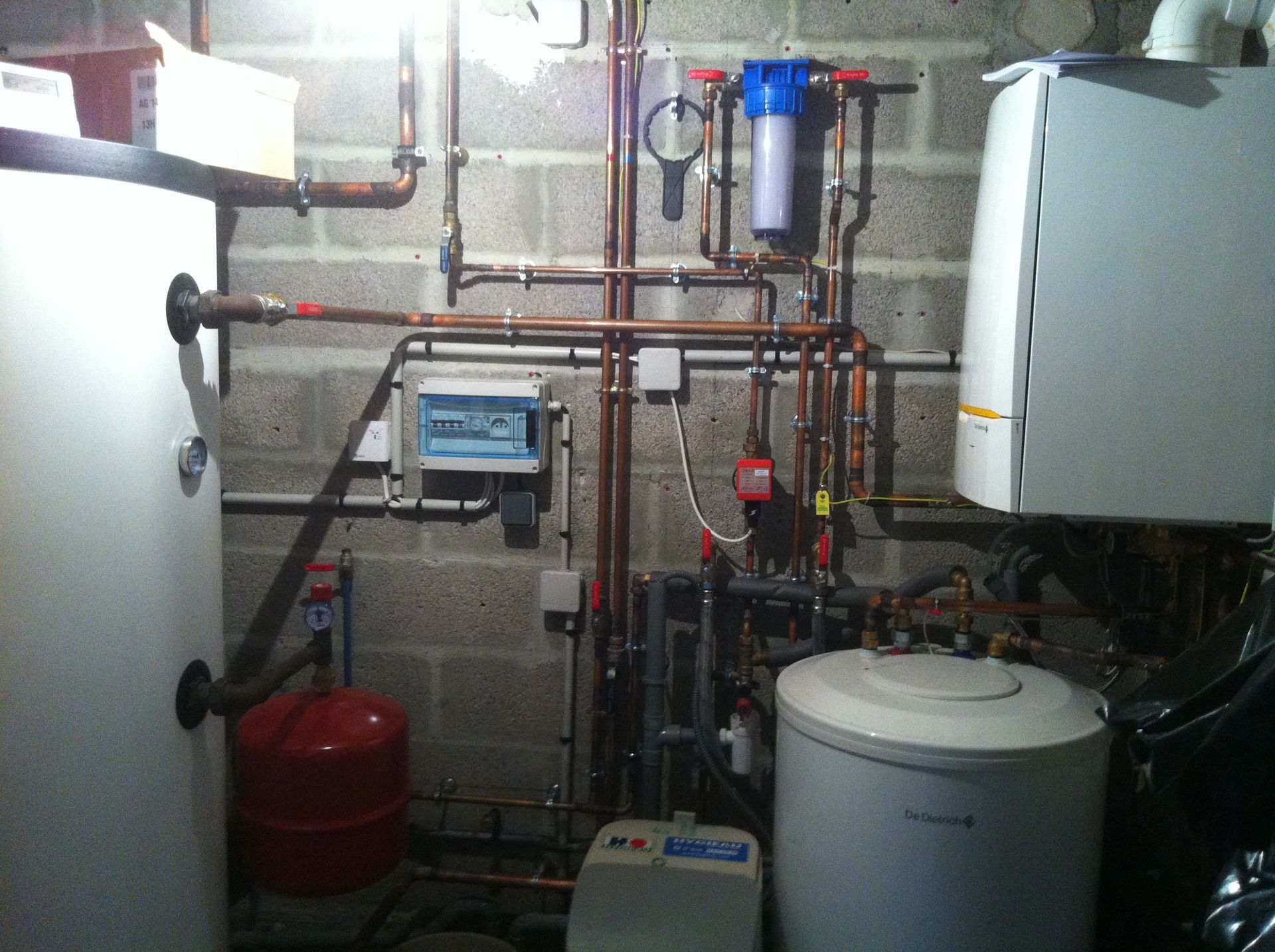 Système de plomberie et de chauffage avec tuyaux en cuivre, réservoir d'eau, filtre et chaudière.