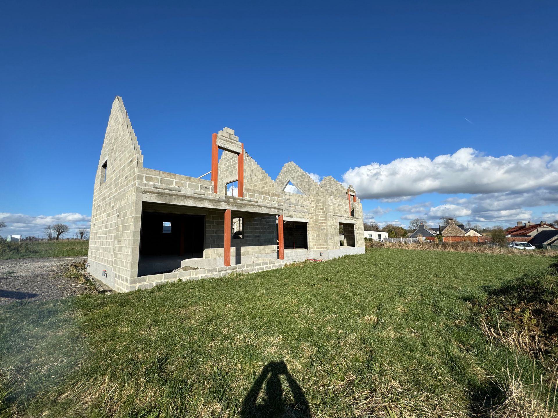 Ruines d'un bâtiment en pierre aux fenêtres vides sur une colline herbeuse sous un ciel bleu