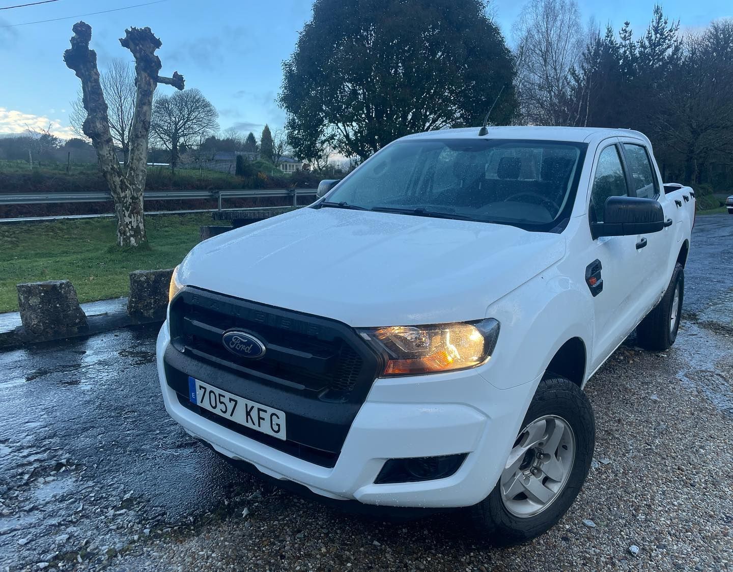 Una camioneta Ford Ranger blanca está estacionada en un camino de grava.