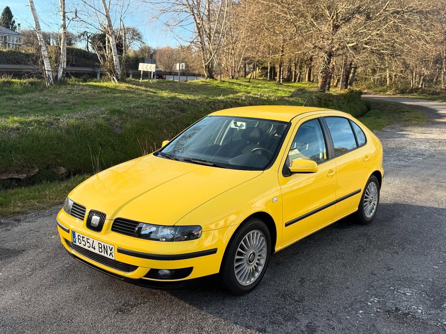 Un coche amarillo está estacionado al costado de la carretera.