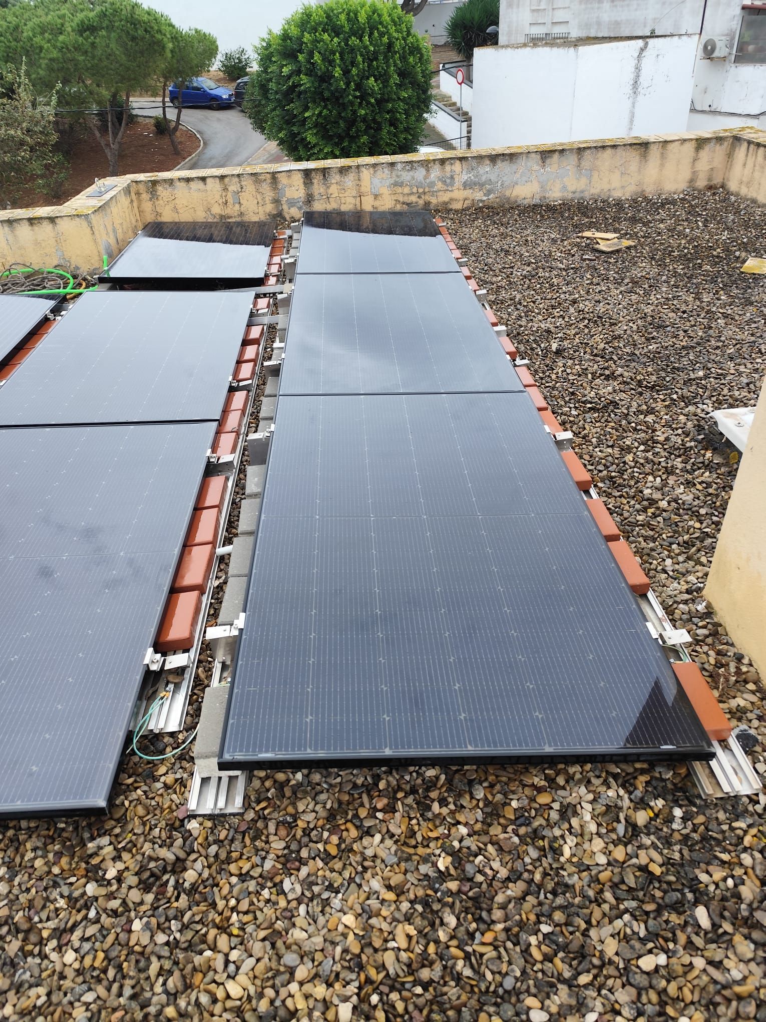 Paneles solares en un campo de hierba bajo un cielo azul brillante con nubes.