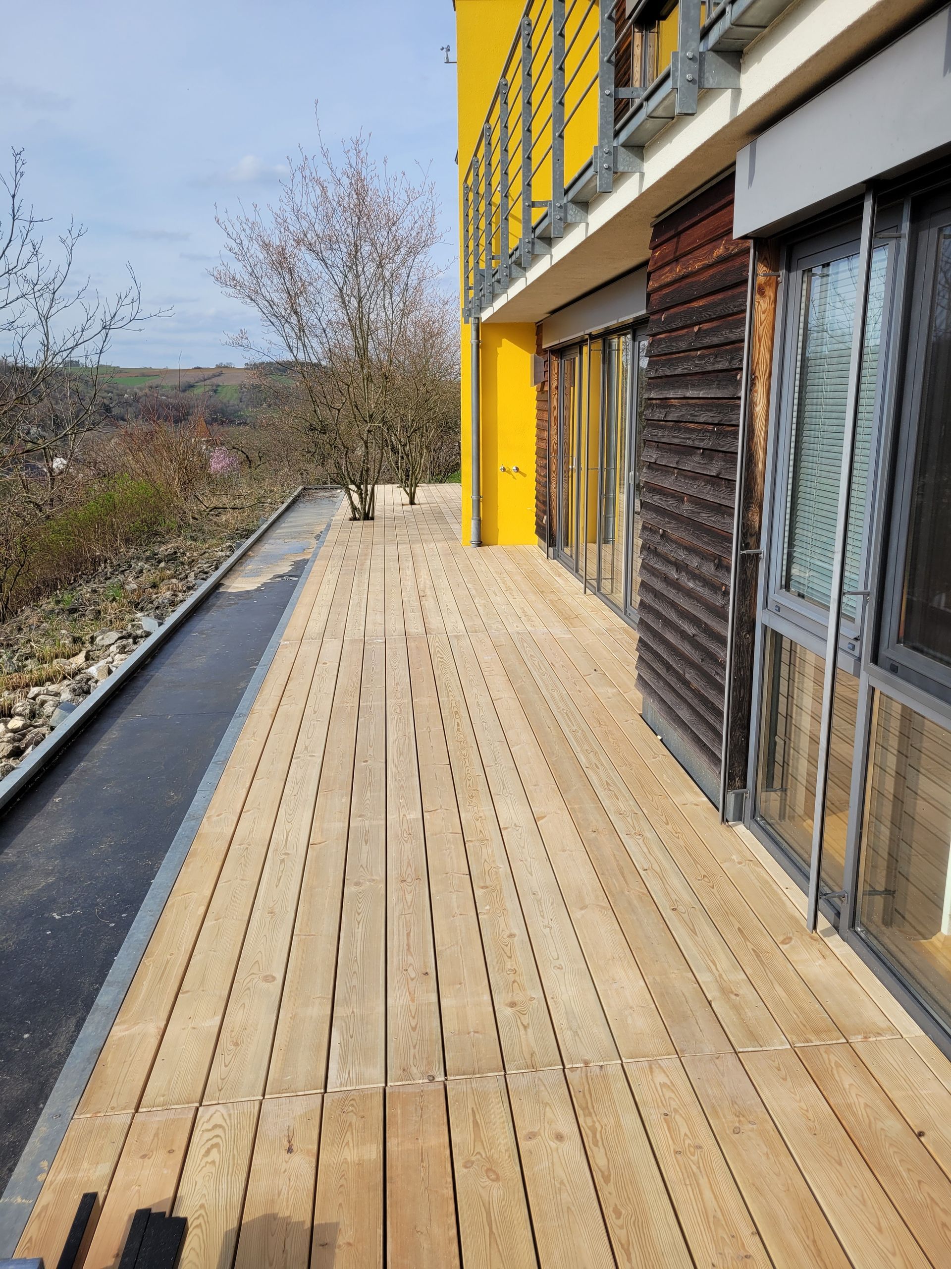 Person, die im Freien mit einer Bohrmaschine Holzplanken befestigt.