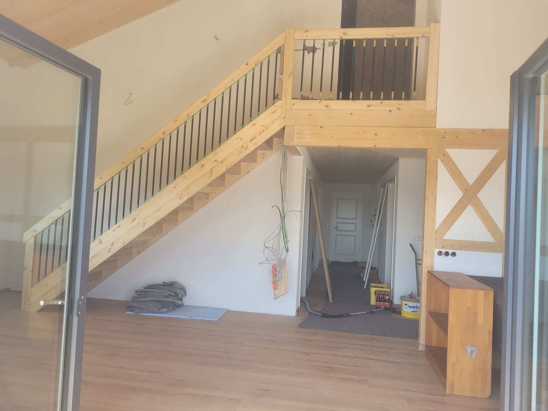 Eine Person arbeitet an einem Türrahmen aus Holz und hält dabei ein kleines Werkzeug in der Hand.