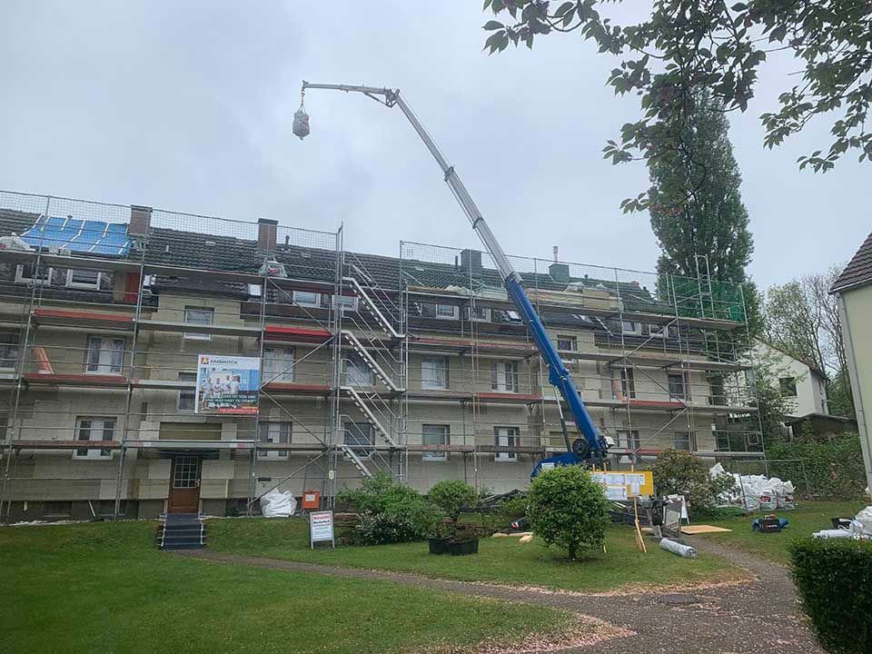 Kran an einem Gebäude mit Gerüst