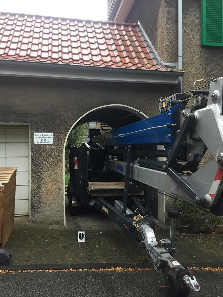 eingeklappter Kran fährt durch ein Tor