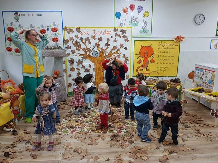 Un grupo de niños está de pie en una habitación cubierta de hojas.