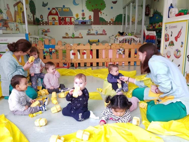 Un grupo de bebés está jugando con juguetes en una habitación.