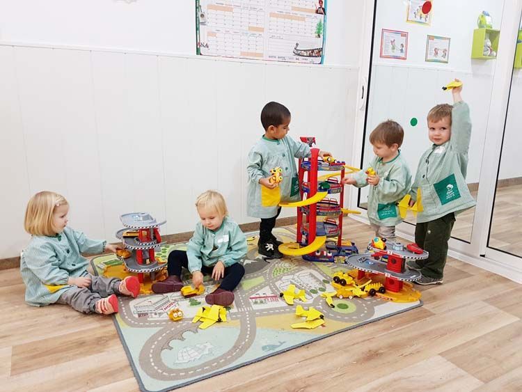 Un grupo de niños está jugando con juguetes en una habitación.