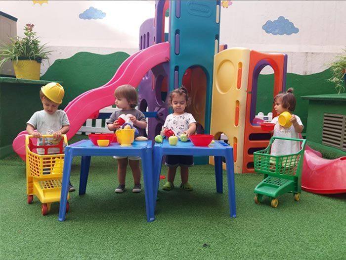 Un grupo de niños está jugando con juguetes en un patio de recreo.