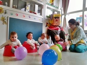 Un grupo de bebés está jugando con globos en una habitación.
