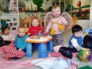 Un grupo de bebés está sentado alrededor de una mesa en una habitación.