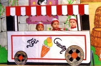 Tres niños están sentados en un carrito de helados.