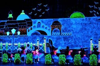 Un grupo de personas está bailando frente a una pared que brilla en la oscuridad.