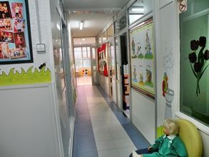 Una muñeca está sentada en una silla en un pasillo.