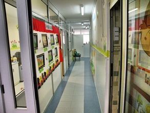 Un largo pasillo con una puerta de cristal y un cuadro en la pared.