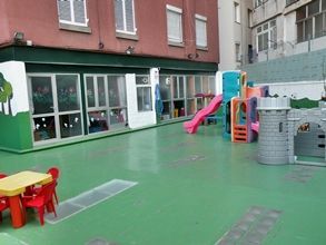 Un patio de juegos con una mesa y sillas frente a un edificio.