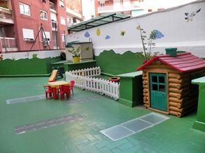 Una zona de juegos con mesa y sillas y una casita.