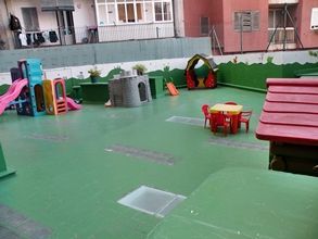 Un parque infantil con mesa, sillas y un tobogán.