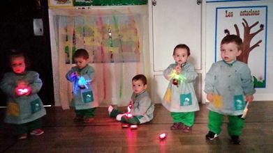 Un grupo de niños está jugando con luces en una habitación oscura.