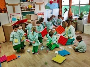 Un grupo de niños está jugando con juguetes en un aula.