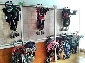 Una fila de cochecitos colgados en una pared de una habitación.
