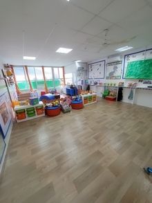 Una habitación grande con suelos de madera y muchos juguetes en ella.