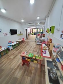 Una habitación grande llena de juguetes y mesas.