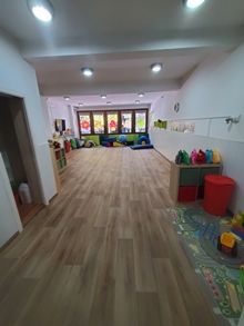 Una habitación grande con suelos de madera y muchos juguetes en ella.