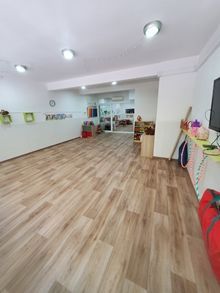 Una habitación grande con suelos de madera y paredes blancas.