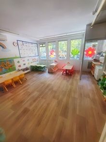 Una habitación con mesas y sillas y muchas ventanas.