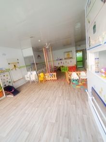 Una habitación grande con suelos de madera y muchos juguetes en ella.