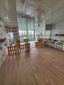 Una habitación grande con suelos de madera y cunas en ella.