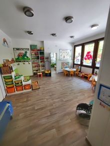 Una habitación grande llena de juguetes, mesas y sillas.