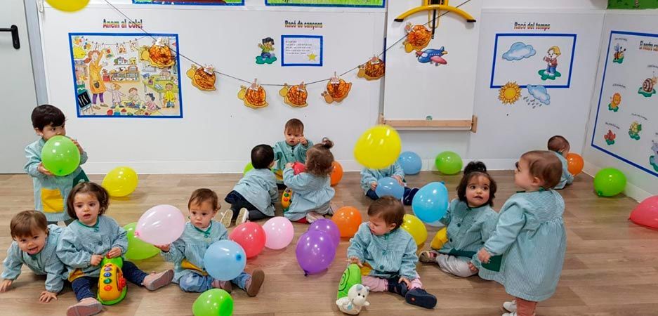 Un grupo de niños está jugando con globos en una habitación.