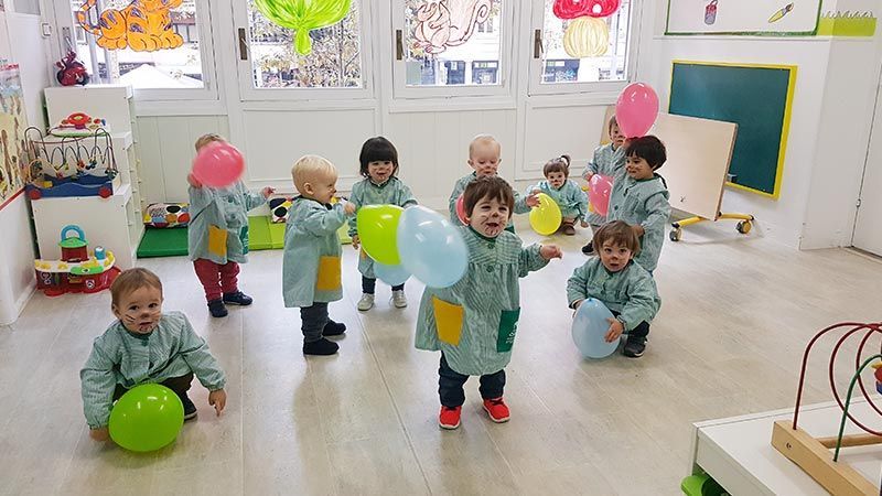 Un grupo de niños está jugando con globos en una habitación.