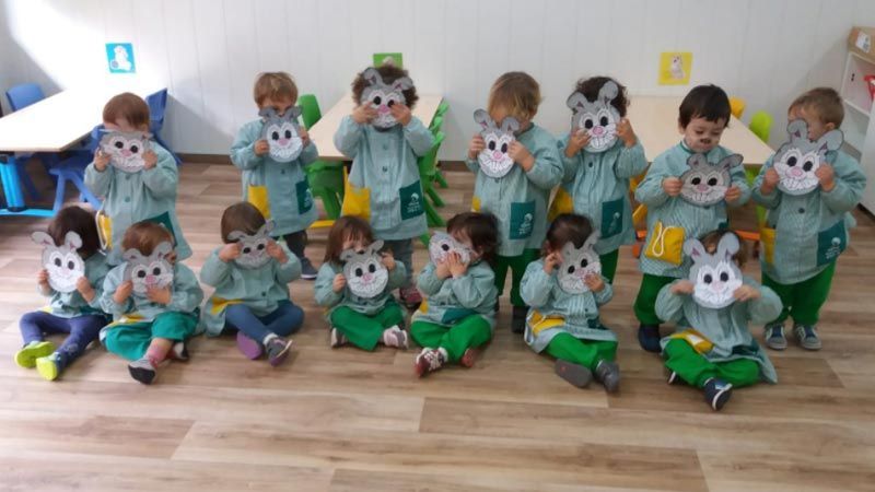 Un grupo de niños con máscaras de conejo en un aula.