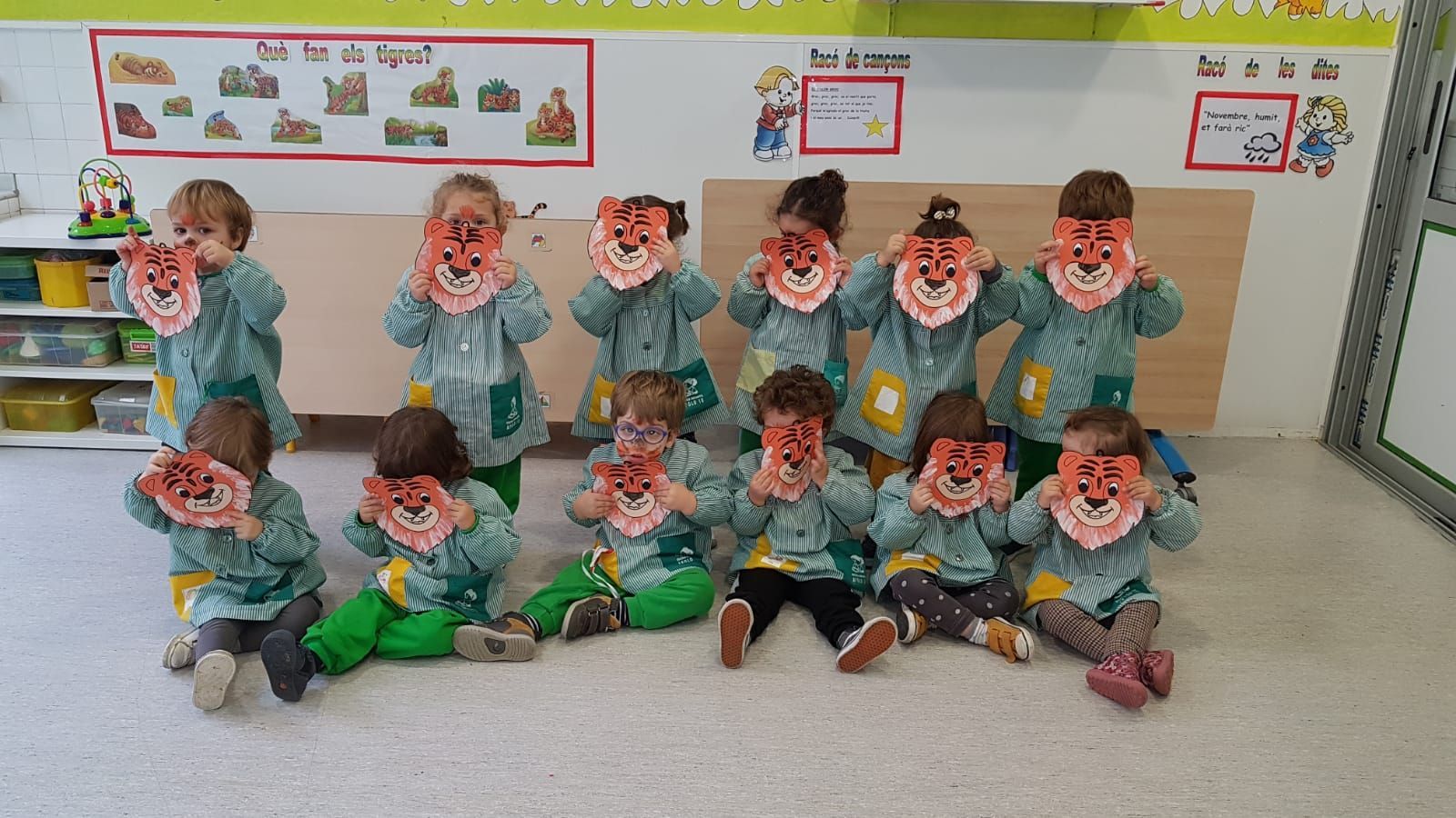 Un grupo de niños lleva máscaras de león en un aula.