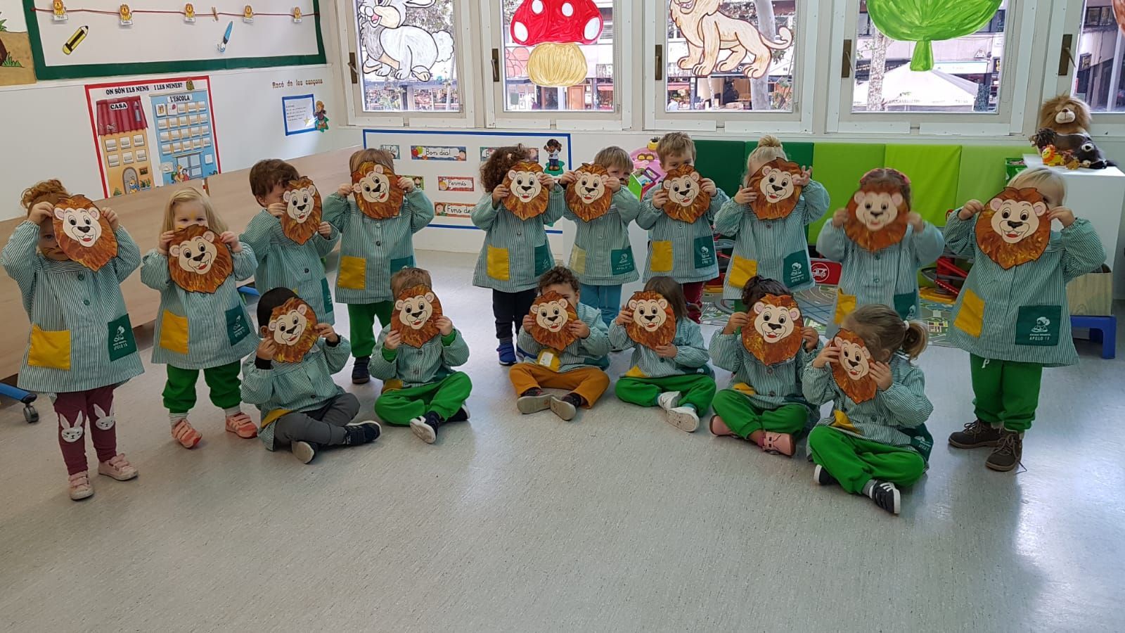 Un grupo de niños vestidos con disfraces de león están sentados en el suelo en un aula.