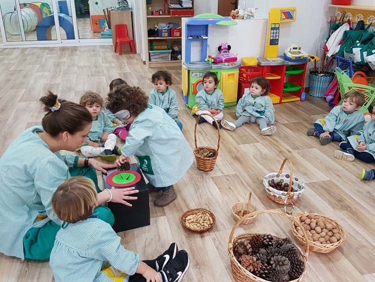 Un grupo de niños está sentado en el suelo en círculo.