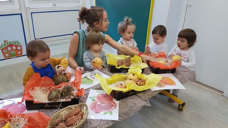 Una mujer está sentada en una mesa con un grupo de niños.