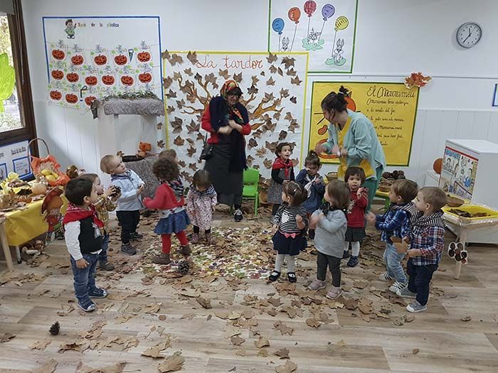 Un grupo de niños está jugando con hojas en un aula.