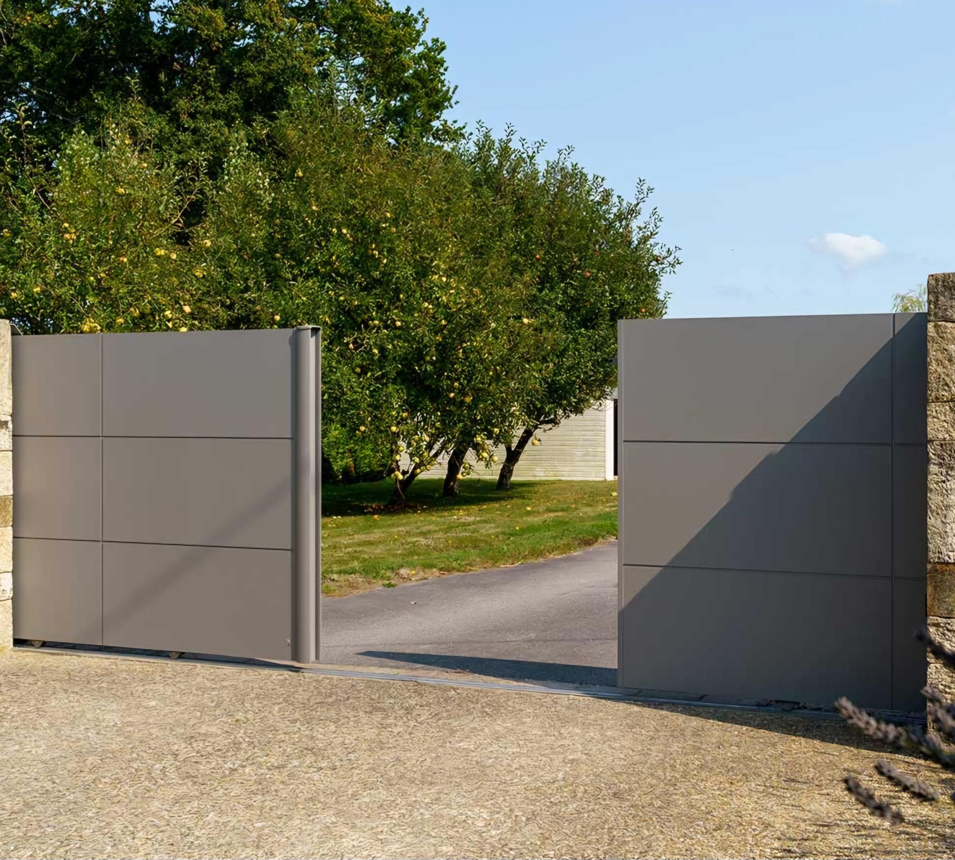 Extérieur d'une maison moderne à deux étages avec murs blancs, porte de garage foncée et claustra vertical en bois à l'étage supérieur