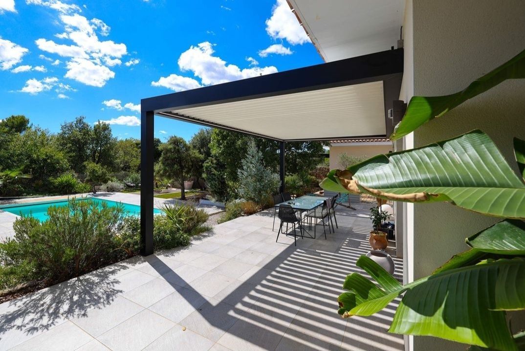 Maison moderne de deux étages avec façade en bois et en verre, terrasse et jardin paysager
