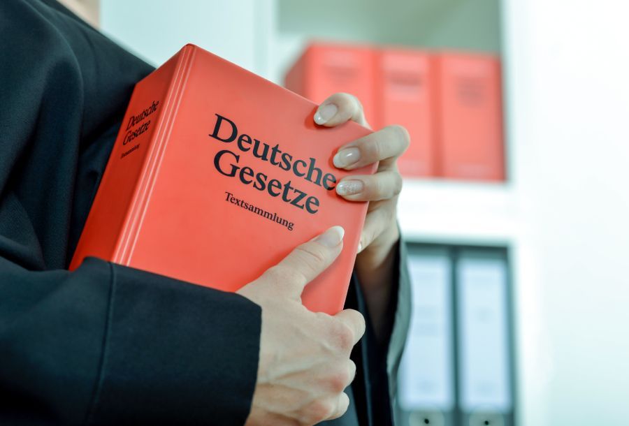 Foto von Rechtsanwältin mit einem orangenen Buch namens Deutsche Gesetze Textsammlung