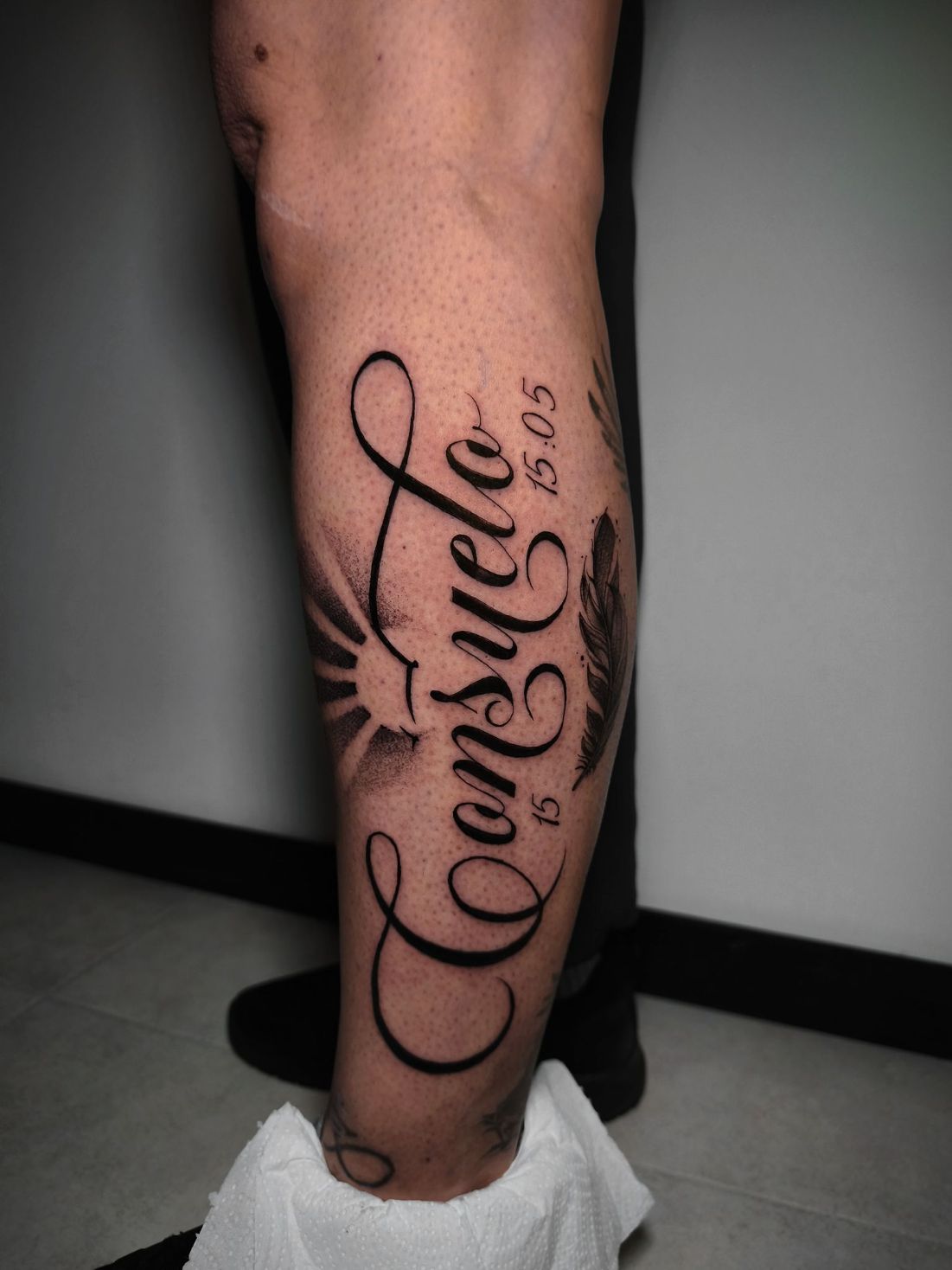 Un tatuaje en la parte inferior de la pierna con el nombre 