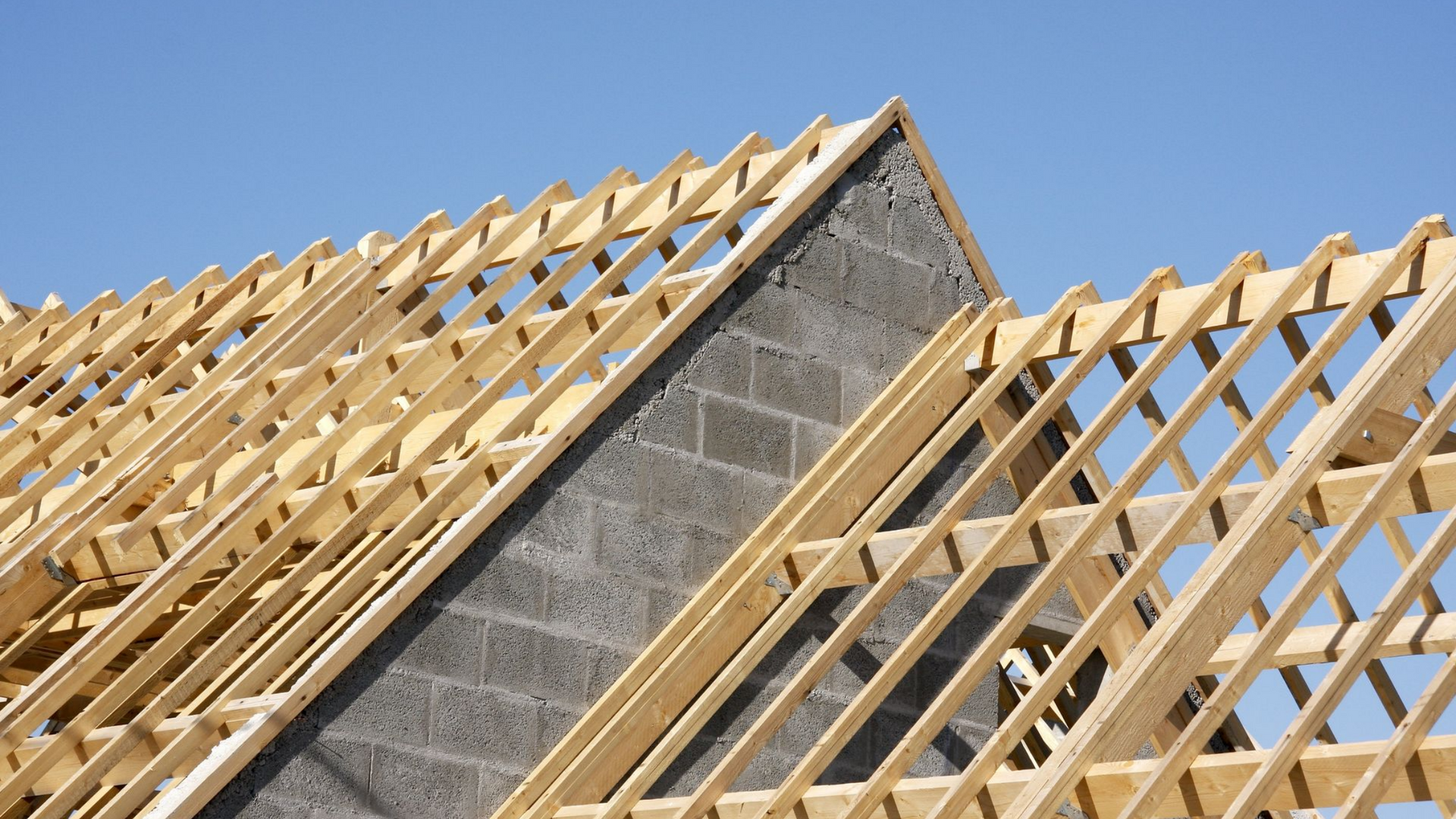 Charpente en bois d'un toit en construction sur fond de ciel bleu