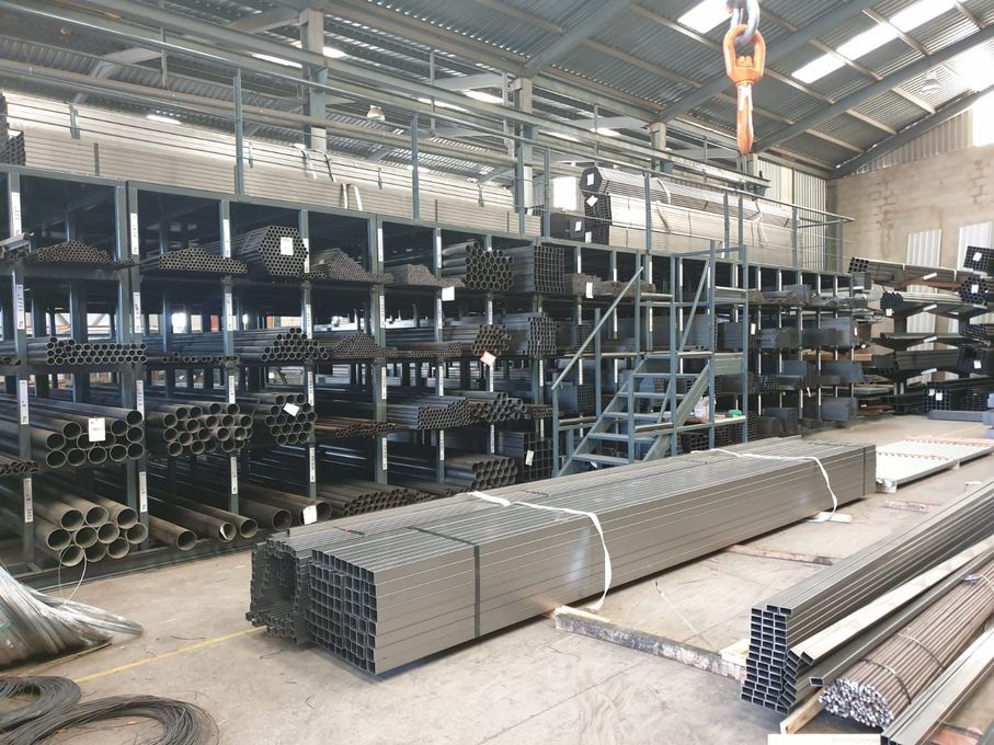 Un gran almacén lleno de tuberías y escaleras de metal.