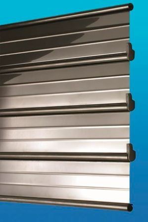 Un primer plano de una persiana metálica sobre un fondo azul.