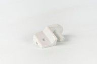 Un par de clips de plástico blanco sobre una superficie blanca.