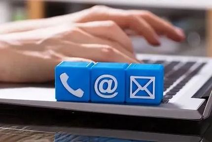 Una persona está escribiendo en una computadora portátil con bloques azules con íconos de contacto en ellos.
